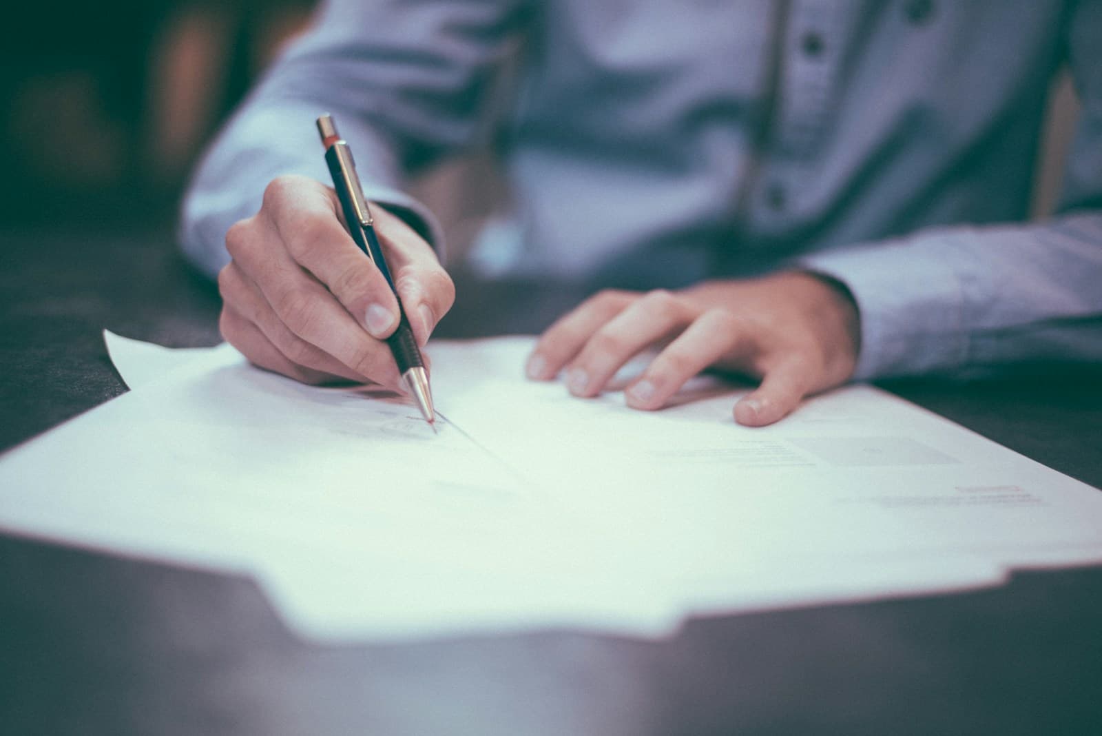 Firma de la documentación de un trámite sobre una mesa de despacho